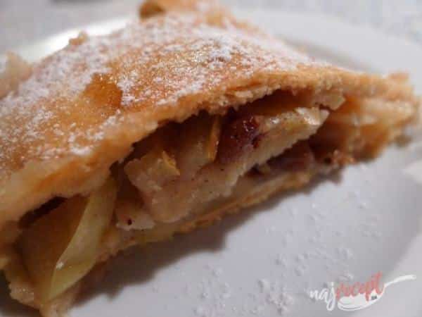 A piece of beer dough strudel filled with apples and almonds