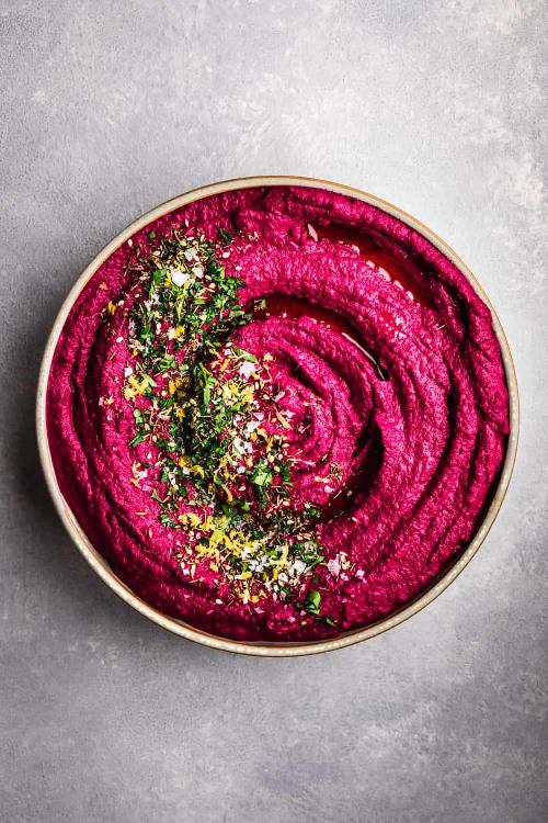 Beet spread with chickpeas and tahini served in a bowl.