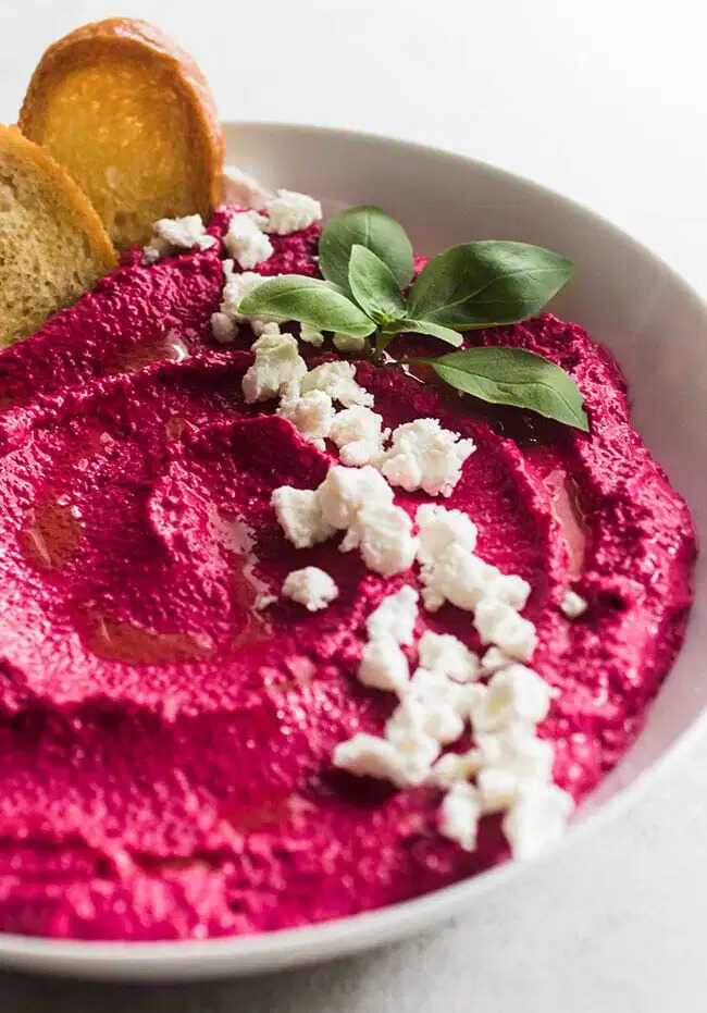 Beet spread served in a bowl, garnished with goat cheese.