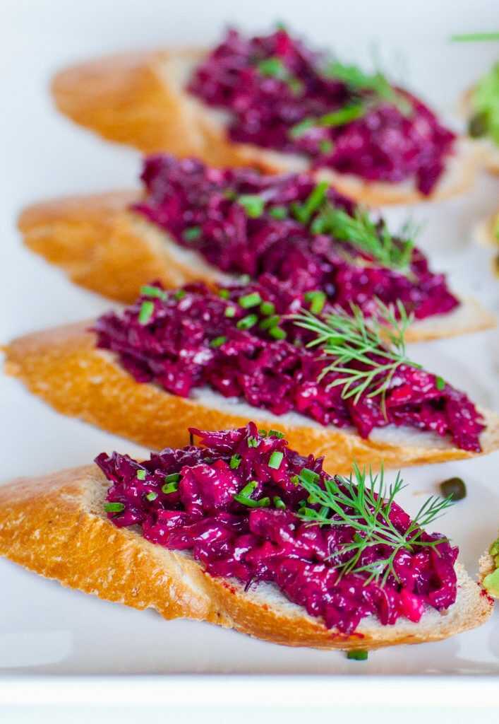 Beetroot dip served on baguette slices, garnished with dill.