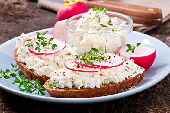 Covered sandwich with spread with radishes and chives.