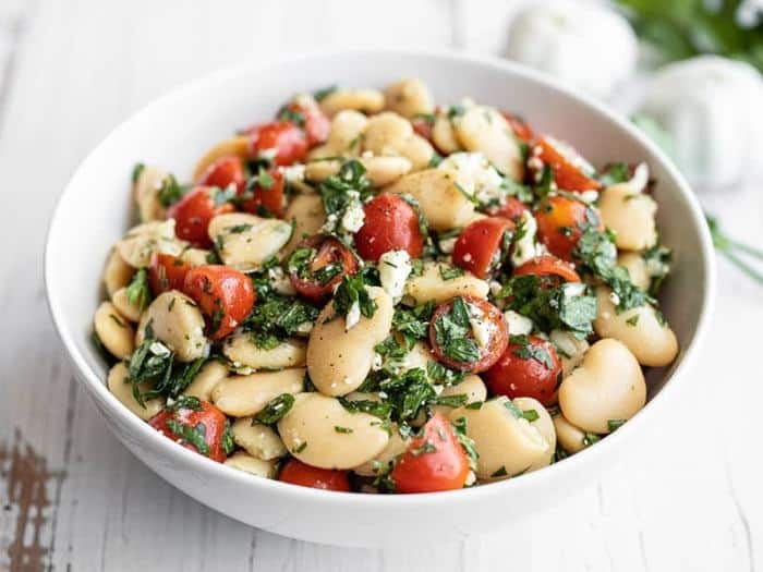 A bowl of salad made from white beans, tomatoes and feta cheese