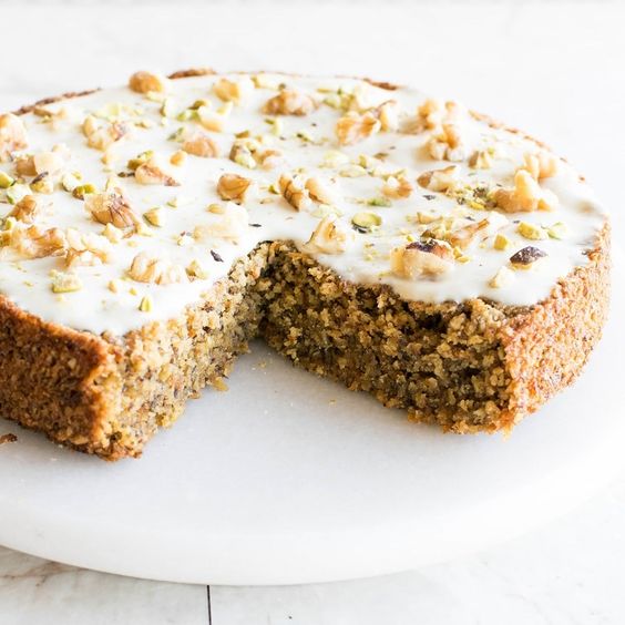 Carrot cake with frosting and roasted nuts.