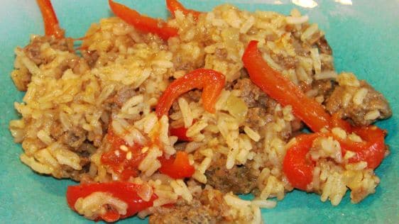 Beef on onions with tomatoes, peppers and rice.