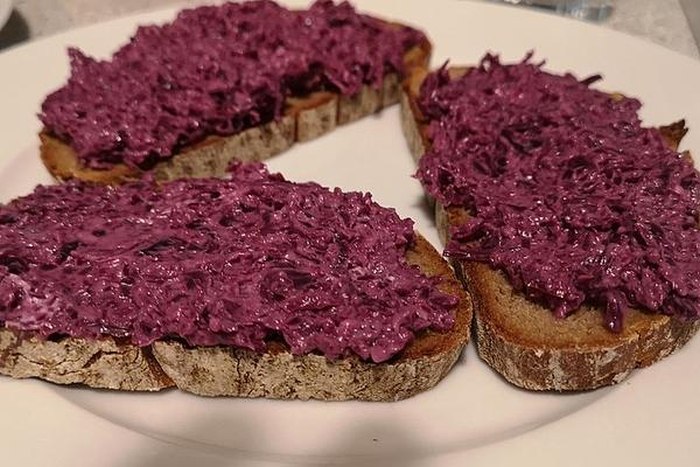 Slices of bread smeared with red cabbage spread.