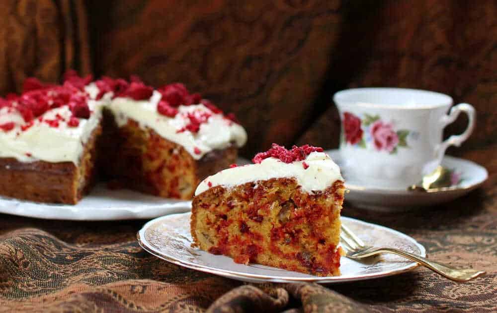 Beetroot cake with ginger and sour cream served on a plate with a fork.