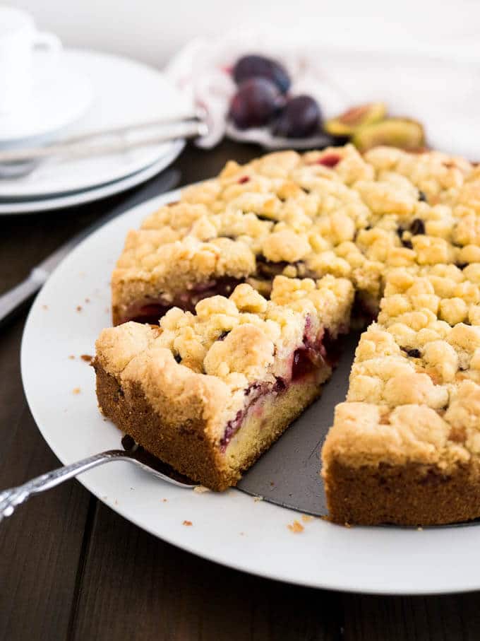 Cake with plums and crumb served on a plate.
