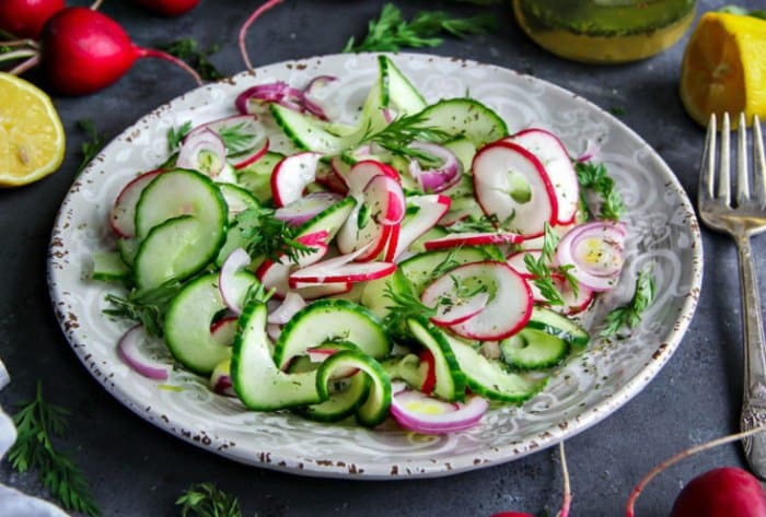 A plate with a mixture of cucumbers and radishes.