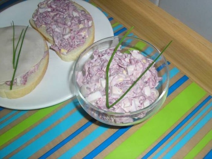 Bowl with egg spread, pickled red cabbage and sausage.