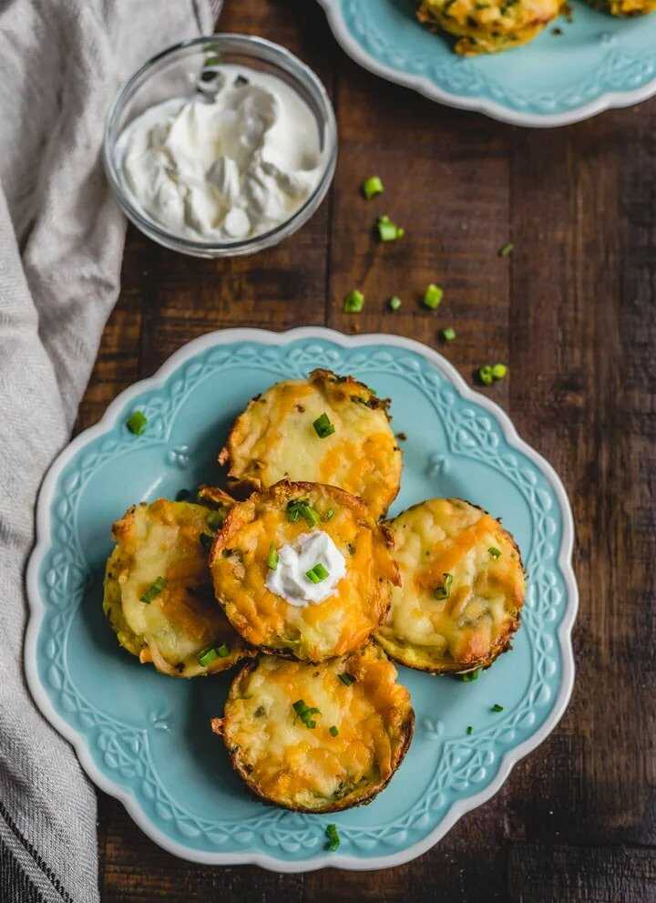 Kartoffelmuffins mit Käse und Spinat, serviert auf einem dekorativen Teller, bestreut mit Schnittlauch.