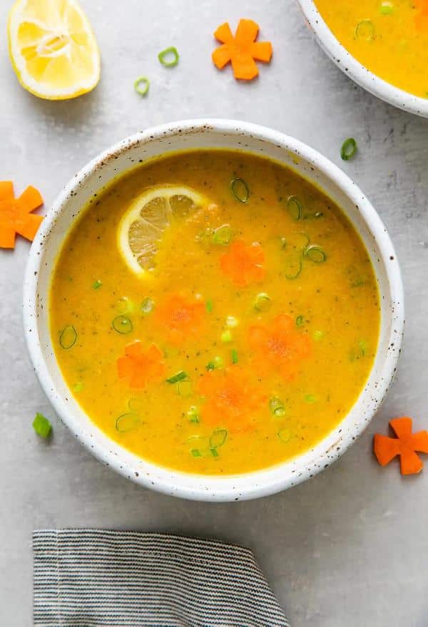 Zucchini soup with carrots, ginger, turmeric and coconut milk served in a deep plate.