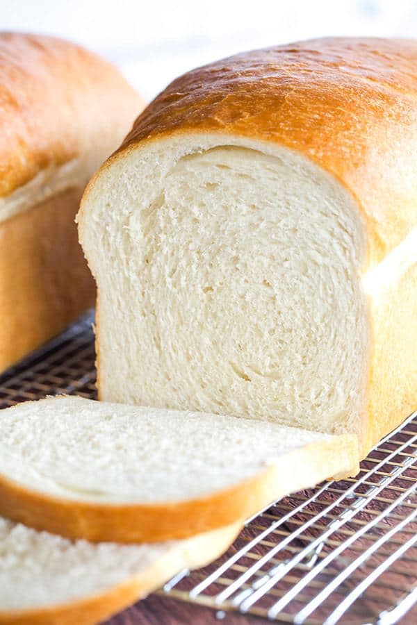 Bílý chléb, rozkrojený, servírovaný na mřížce.