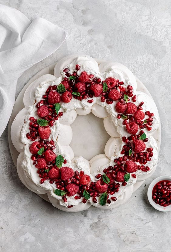 Pavlova cake decorated with fresh fruit and cream.