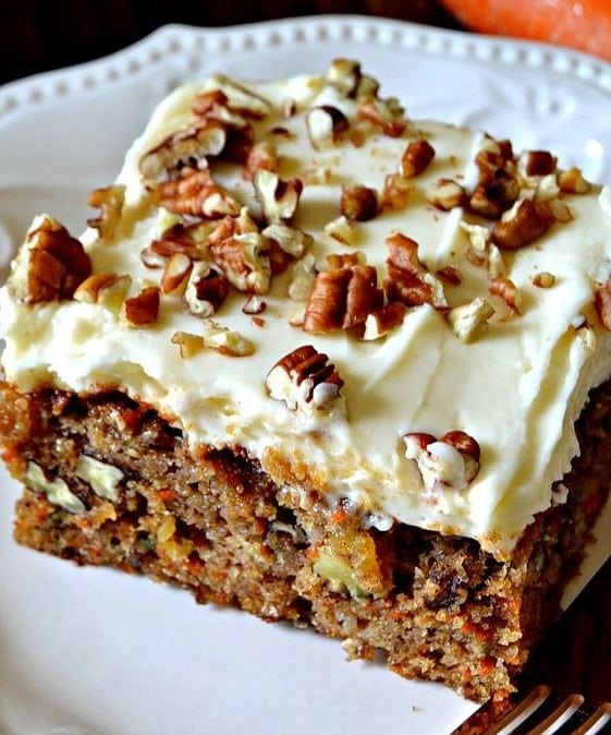 Carrot cake with chopped pecans and spread with cream frosting.