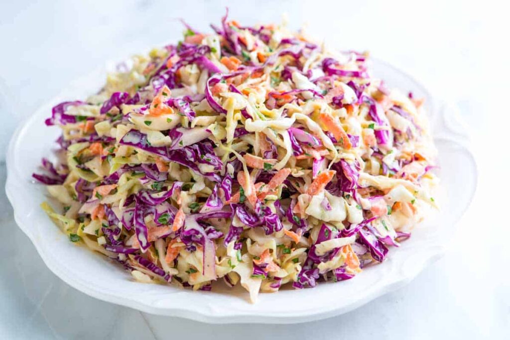 Cabbage salad with carrots and mayonnaise served on a large plate.