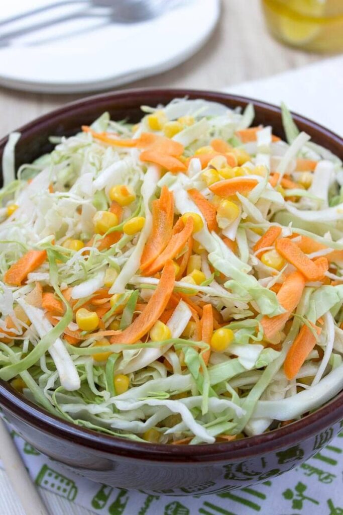 Carrot, celery, corn and cabbage salad served in a bowl.