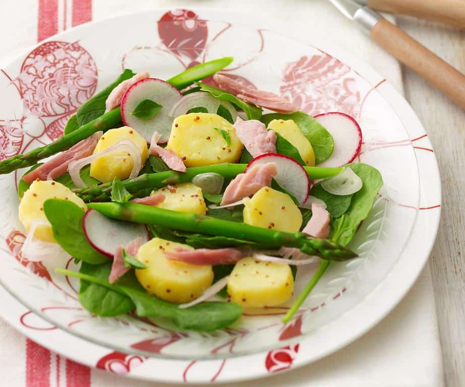 Radish, asparagus, ham and potato salad served on a plate.