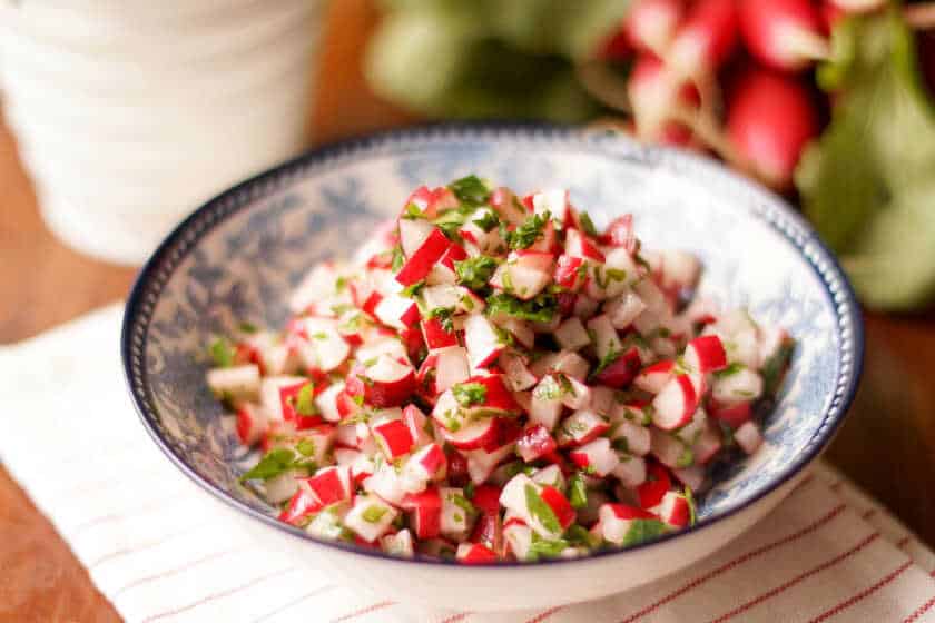Radish salad with fresh parsley served in a deep plate.