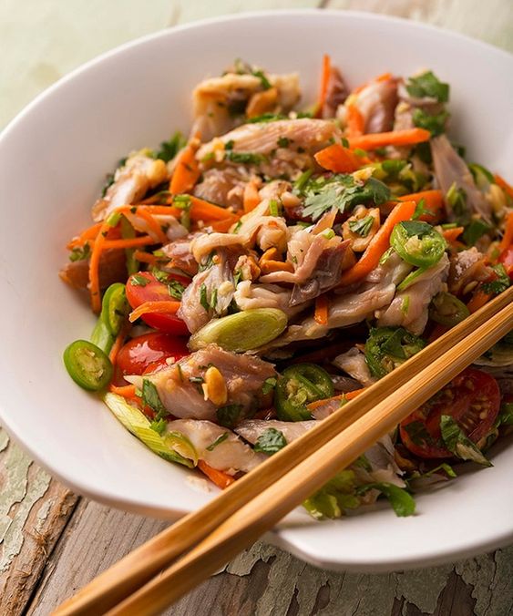 Thailändischer Salat mit Gemüse, Fisch und chinesischen Essstäbchen.