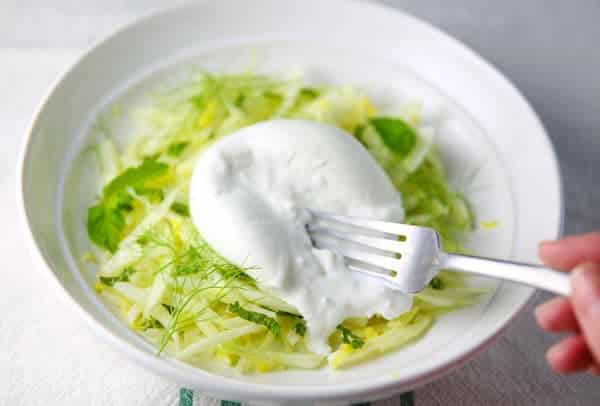 Fennel salad with burrata on a plate with a fork.