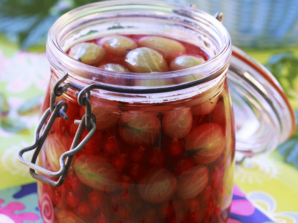 Canned gooseberry with currants in a glass.