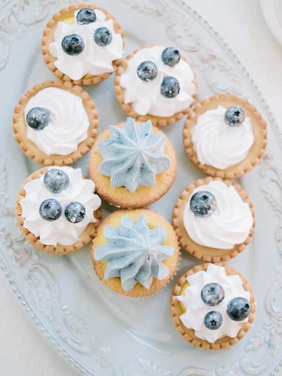 Blueberry cupcakes decorated with vanilla cream and blueberries.