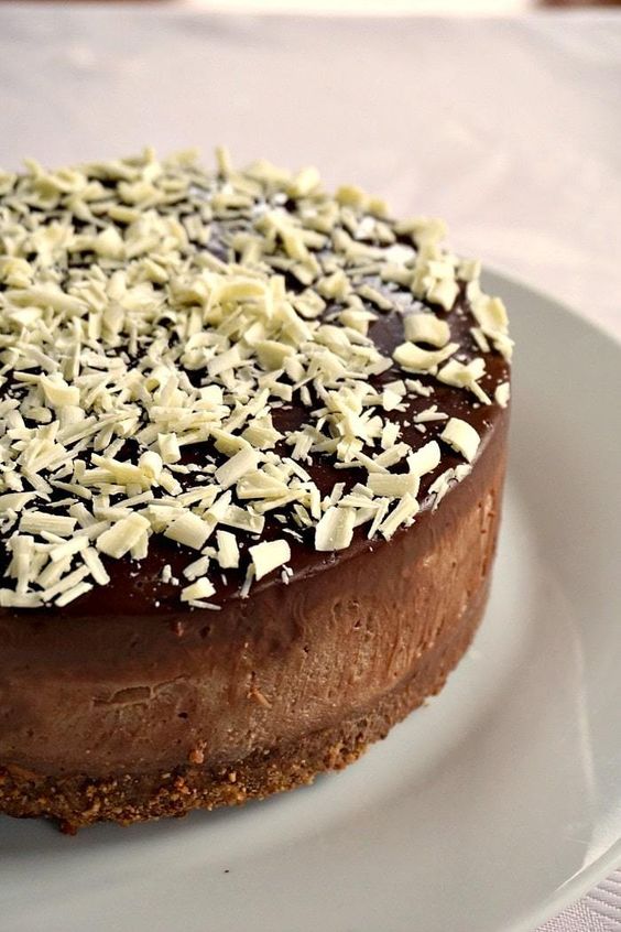 Ungebackener Schokoladenkuchen, gefüllt und mit Schokolade bestreut.