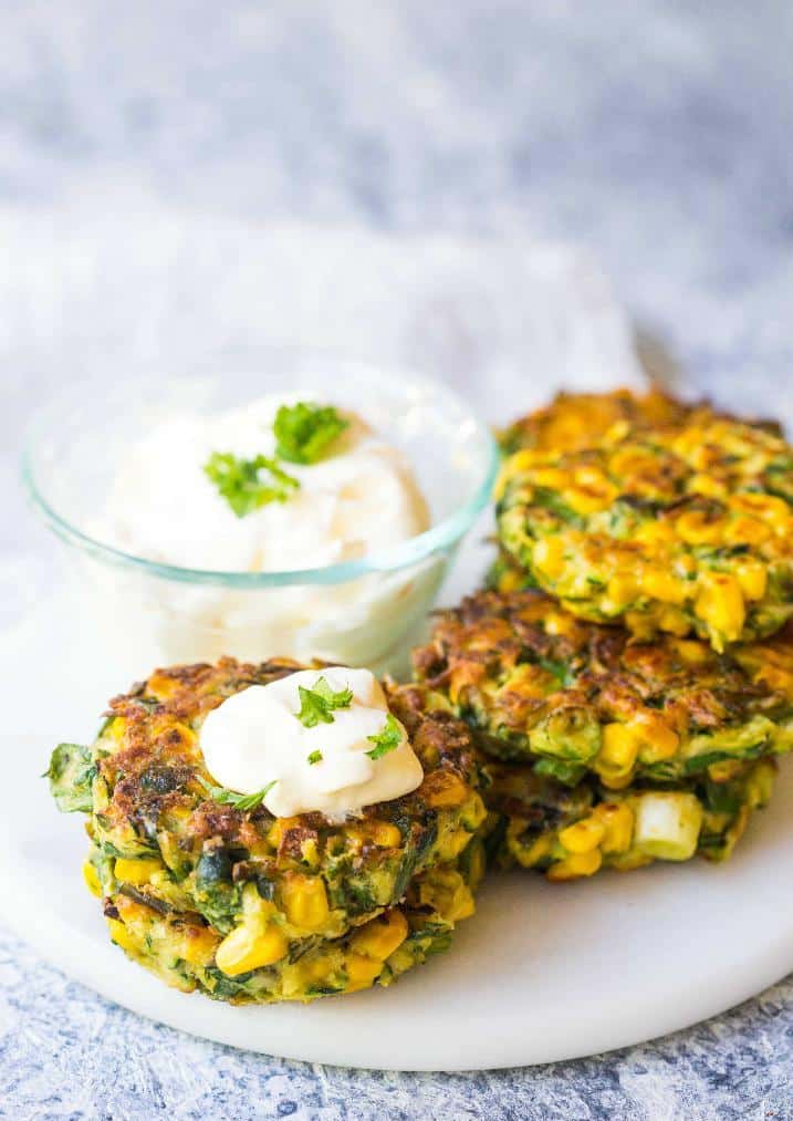 Zucchini meatballs with sweet corn served with a bowl of dip.
