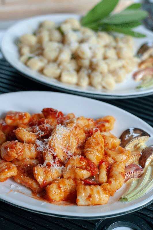 Gnocchi mit Tomatensauce und Parmesan auf einem Teller serviert.