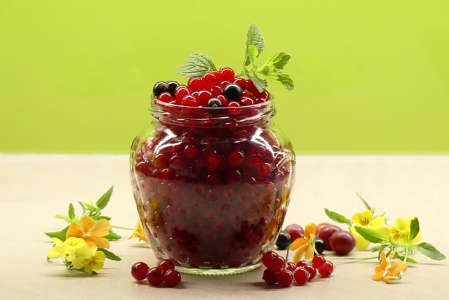 Red currant in a glass with flowers.