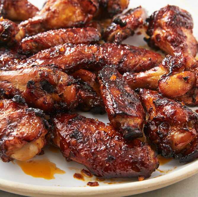 Chicken wings in honey and soy sauce served on a plate.