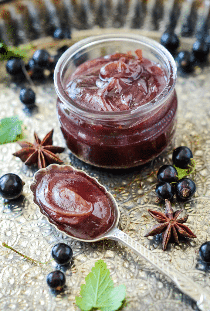 Blackcurrant marmalade in a jar and spices.