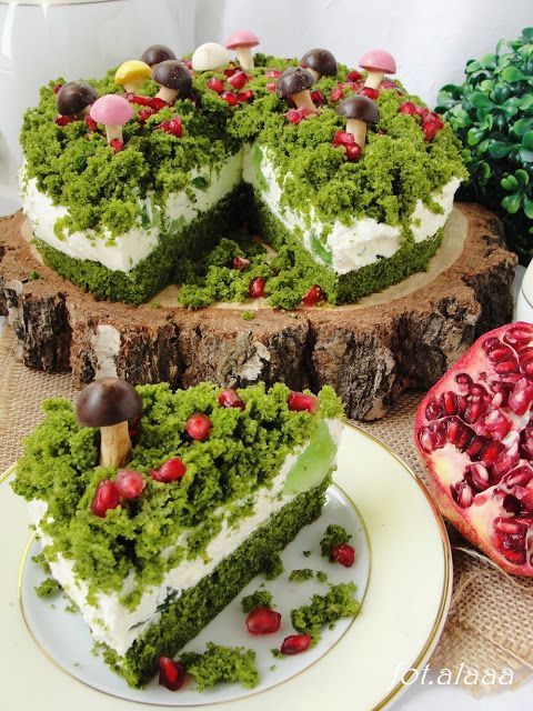 Nadýchaný dort promazaný bílým krémem a posypaný zeleným sypáním.