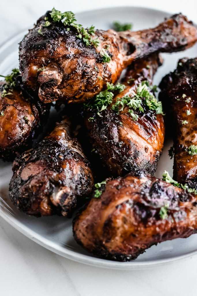 Baked marinated chicken drumsticks in balsamic served on a plate.