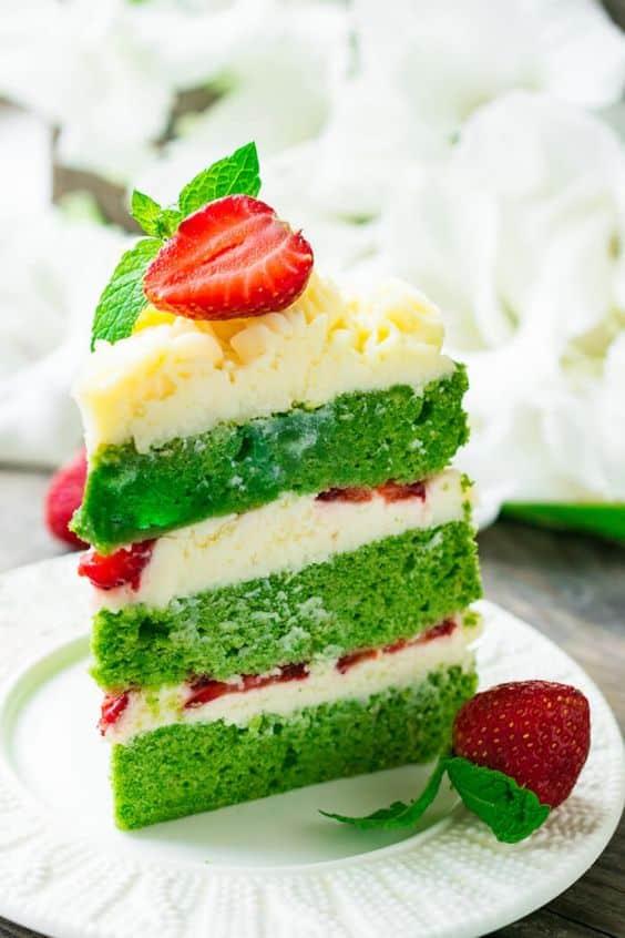 Ein Stück grüner Kuchen mit Vanillecreme und mit Erdbeeren aromatisiert.