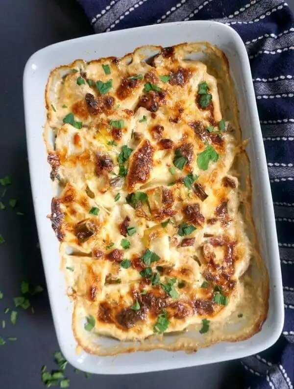 Creamy celery gratin with bacon and leek in a baking dish.