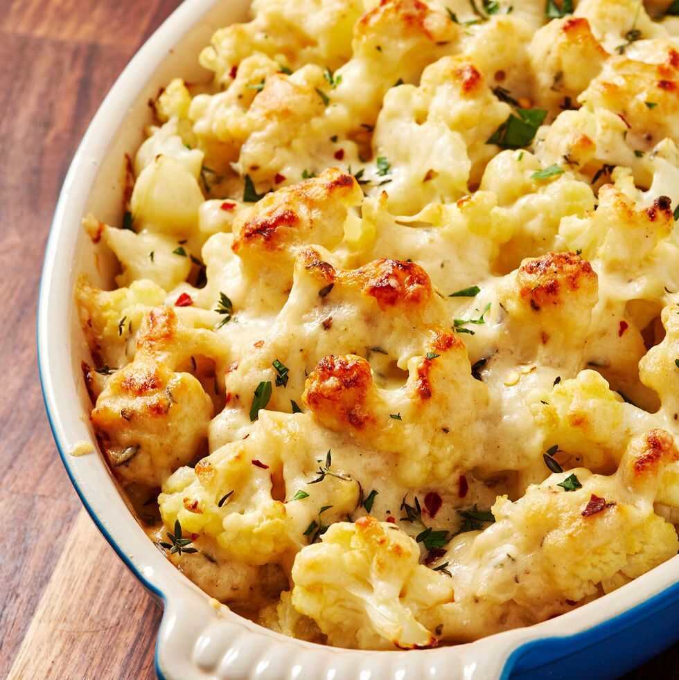 Baked cauliflower sprinkled with parsley served in a baking dish.