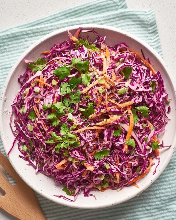 Fresh red cabbage salad with mayonnaise, carrots, cranberries and nuts.