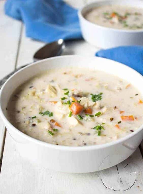 Cremige Suppe mit Huhn und Gemüse in einer tiefen Schüssel.