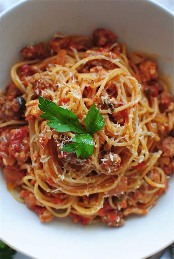 Italské těstoviny s rajčatovým protlakem a posypané parmezánem.