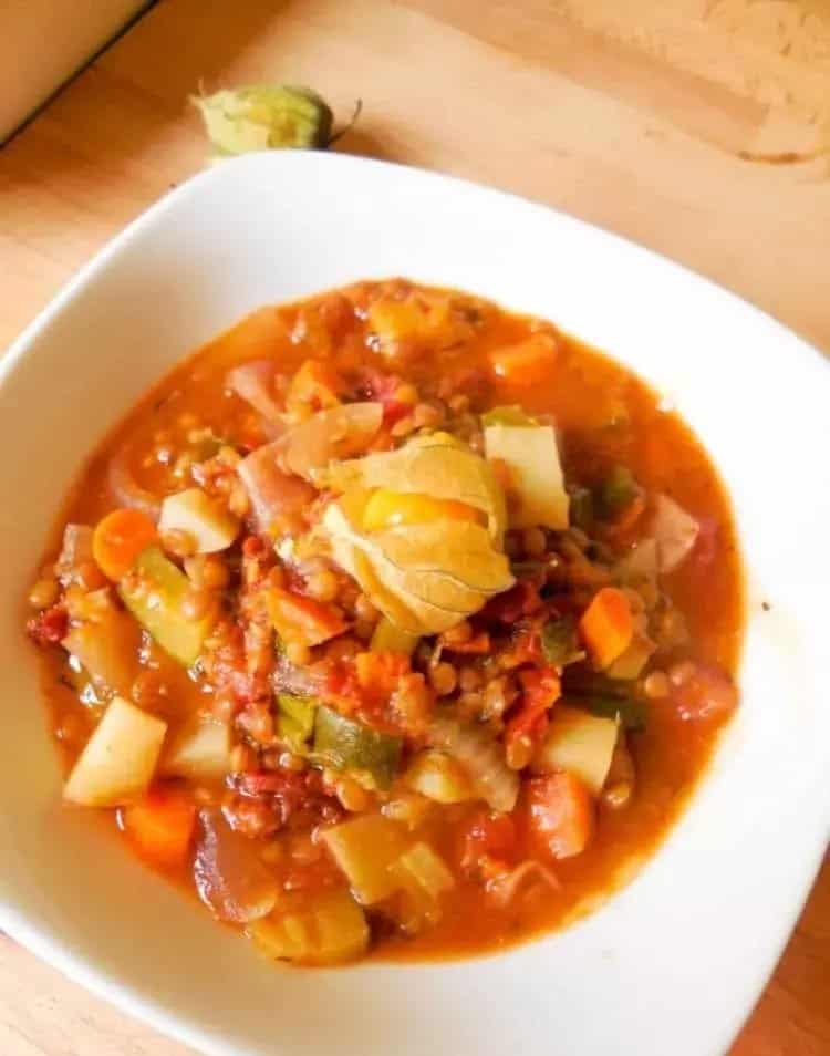 Stew made of potatoes and other vegetables served in a deep plate.