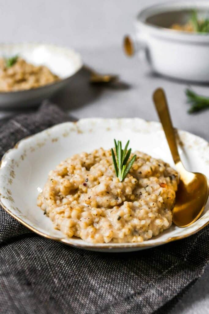 Gluten-free risotto with parmesan served on a plate with a spoon.