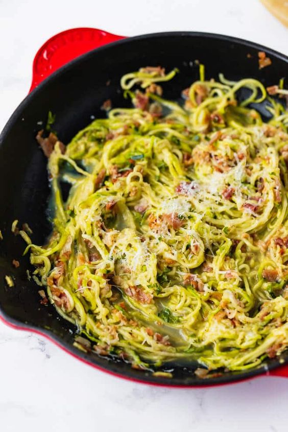 Klassische italienische Carbonara mit Zucchini-Nudeln, Ei und Speck.