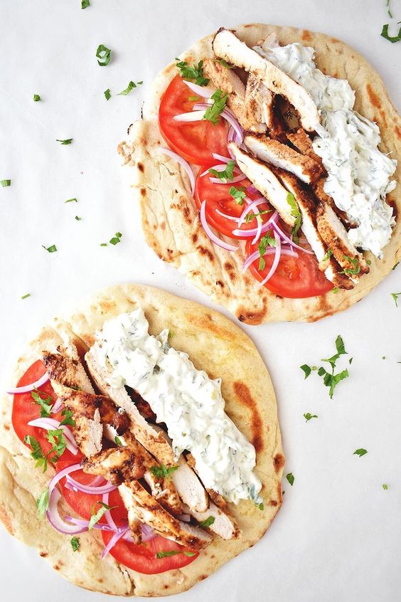 Juicy chicken placed on a fluffy pita with tzatziki.