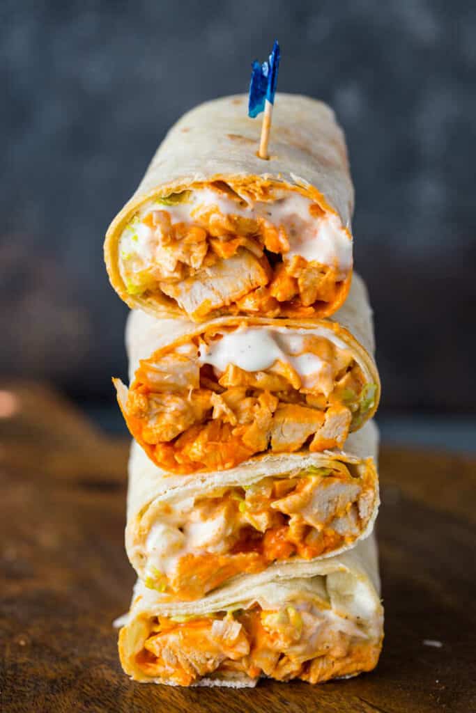 Spicy chicken wraps with ranch dressing stacked on top of each other.