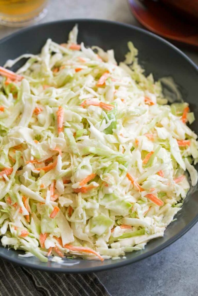 Cabbage salad with carrots and mayonnaise dressing served in a bowl.