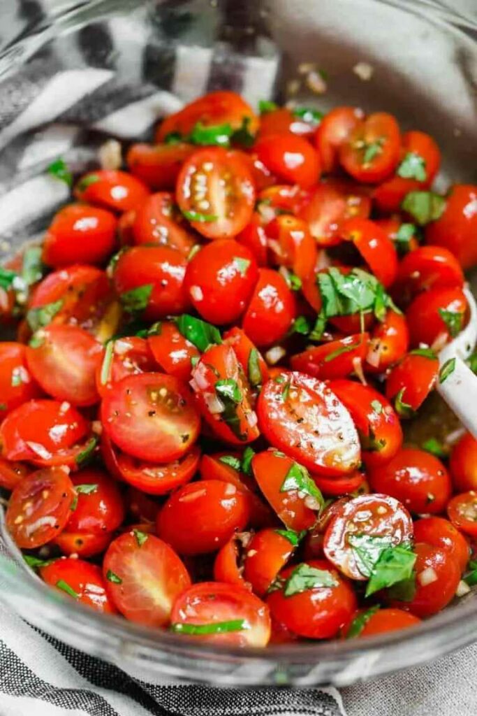 Tomato salad with basil served in a salad bowl.