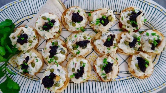 Canapés smeared with mackerel spread and decorated with caviar.
