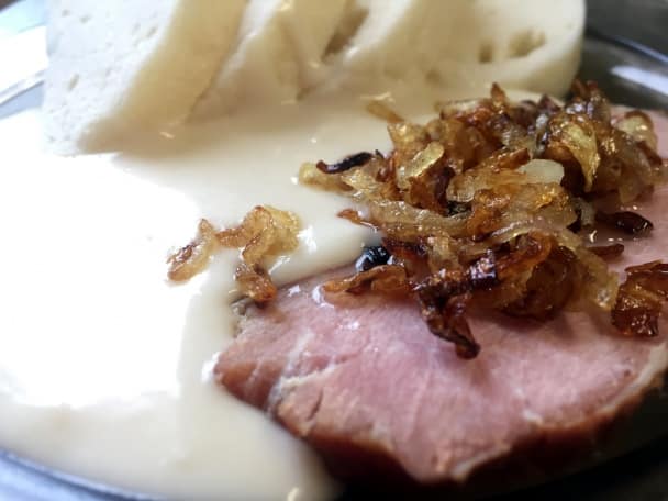 Slice of smoked meat with fried onion, served with horseradish sauce and bread dumpling.