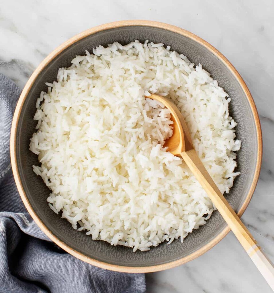 Rýže servírovaná v míse s vařečkou.